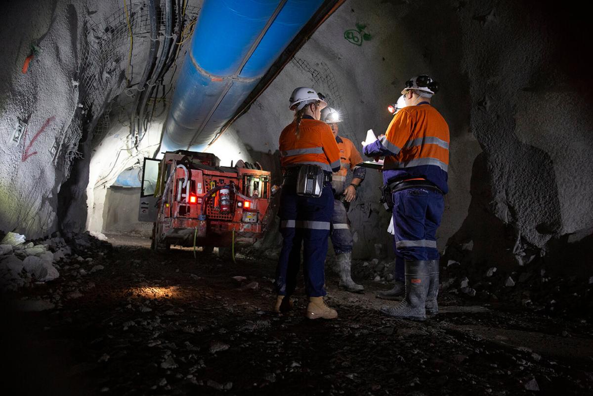 Four miners in full PPE and machinery underground